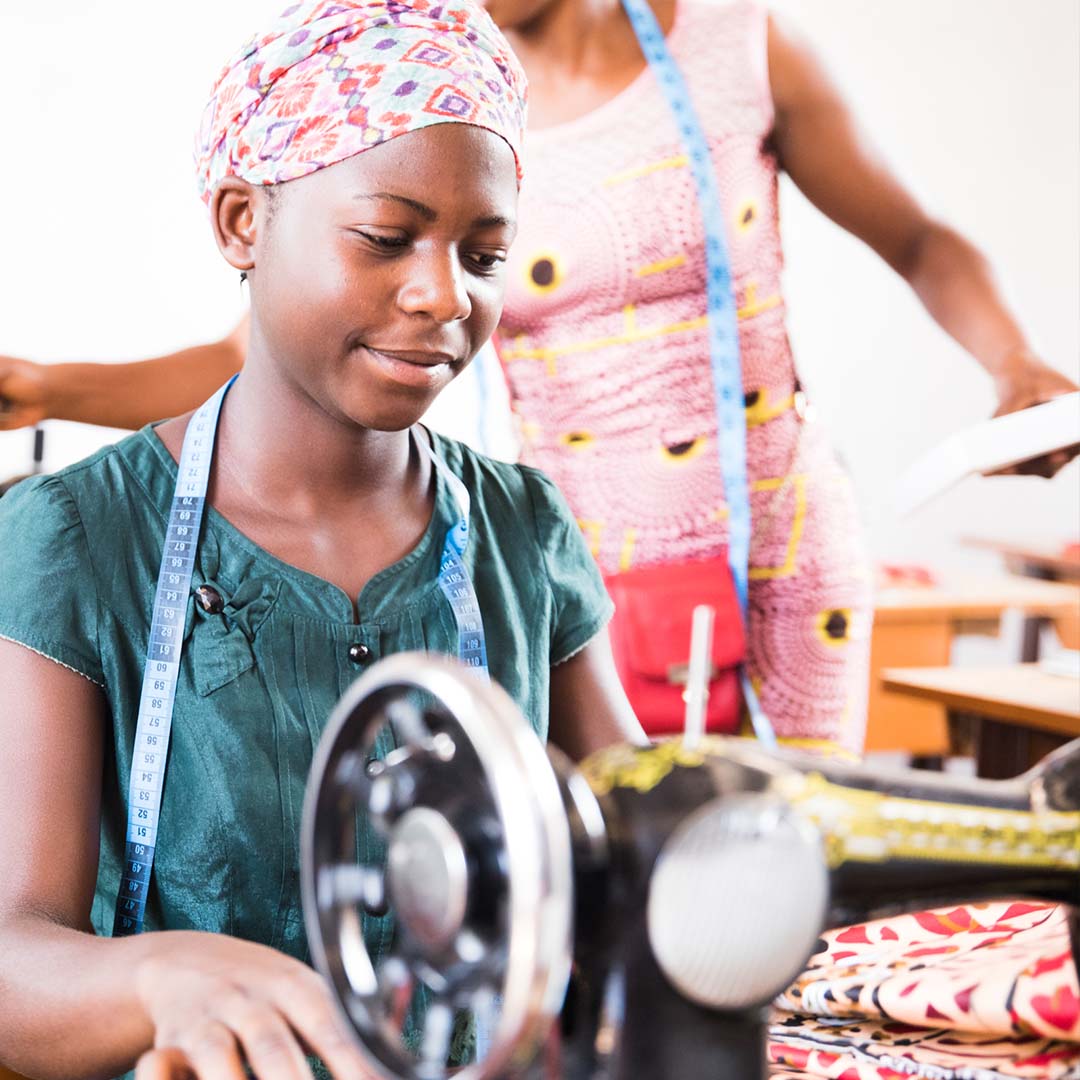 Kongolesisk jente som syr klær med symaskin. Foto.